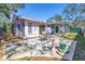 The backyard shows a concrete patio with room for outdoor furniture with a lilac colored house at 5010 109Th N Way, St Petersburg, FL 33708