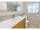 Bathroom featuring a large white countertop, framed mirrors, and natural wood cabinets at 5010 109Th N Way, St Petersburg, FL 33708