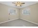 A simple bedroom with two windows, neutral walls and ceiling fan, perfect for rest and relaxation at 5010 109Th N Way, St Petersburg, FL 33708