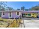 This light purple house features a carport and a white-trimmed glass door and window at 5010 109Th N Way, St Petersburg, FL 33708