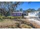 Charming light purple single-story home with mature tree and black chain link fence at 5010 109Th N Way, St Petersburg, FL 33708