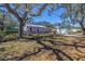 Charming, light purple single-story home with mature tree and black chain link fence at 5010 109Th N Way, St Petersburg, FL 33708