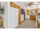 The kitchen features wood cabinets, white appliances, terrazzo flooring and access to the dining area at 5010 109Th N Way, St Petersburg, FL 33708