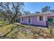 This light purple house features a white-trimmed glass door and window plus lovely green front yard at 5010 109Th N Way, St Petersburg, FL 33708