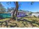 This light purple house features a green front yard and a tree for shade at 5010 109Th N Way, St Petersburg, FL 33708