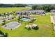 Aerial view of townhouse community with a pond and pool house, parking, green spaces, and landscaping at 5332 Riverwalk Preserve Dr, New Port Richey, FL 34653