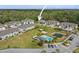 Elevated view of a townhouse community with a pond and pool, parking, green spaces, with arrow pointing at unit at 5332 Riverwalk Preserve Dr, New Port Richey, FL 34653