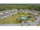 Aerial view of a gray townhouse community with a pond, parking, green spaces, and landscaping at 5332 Riverwalk Preserve Dr, New Port Richey, FL 34653