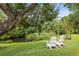 Relaxing backyard with two Adirondack chairs overlooking lush greenery and a creek at 5332 Riverwalk Preserve Dr, New Port Richey, FL 34653