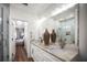 Modern bathroom features dual sinks, large mirrors, and a walk-in shower with neutral color palette at 5332 Riverwalk Preserve Dr, New Port Richey, FL 34653