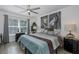 Comfortable bedroom featuring a large bed, art and a ceiling fan at 5332 Riverwalk Preserve Dr, New Port Richey, FL 34653