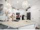 Bright and airy kitchen with white cabinets, marble countertops, modern appliances, and elegant chandelier lighting at 5332 Riverwalk Preserve Dr, New Port Richey, FL 34653