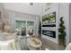 Cozy living area featuring a modern fireplace, large TV, and sliding glass doors to the outdoor patio at 5332 Riverwalk Preserve Dr, New Port Richey, FL 34653