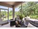 Relax on this screened-in patio, featuring comfortable wicker seating and scenic views at 5332 Riverwalk Preserve Dr, New Port Richey, FL 34653
