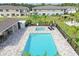 Aerial view of a community pool area, a hot tub, with plenty of lounge seating and a pool house at 5332 Riverwalk Preserve Dr, New Port Richey, FL 34653