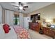 Comfortable bedroom featuring a ceiling fan, large window, and wood dresser with TV and entertainment system at 5646 Sunset Falls Dr, Apollo Beach, FL 33572