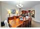 Elegant dining room with wood table, chandelier, and decorative mirror, open to the kitchen at 5646 Sunset Falls Dr, Apollo Beach, FL 33572
