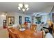 Bright dining room featuring a chandelier, wood table, and open access to the living room at 5646 Sunset Falls Dr, Apollo Beach, FL 33572