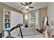 Bright and airy exercise room with a ceiling fan, large window, and fitness equipment at 5646 Sunset Falls Dr, Apollo Beach, FL 33572