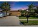 Charming one-story home featuring a well-manicured lawn, palm trees, and a driveway leading to a two-car garage at 5646 Sunset Falls Dr, Apollo Beach, FL 33572