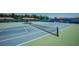 View of the community tennis courts with blue fencing and green playing surface at 5646 Sunset Falls Dr, Apollo Beach, FL 33572