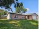 Back view of a brick home showing mature landscaping and a fenced yard at 603 Southwood Cv, Brandon, FL 33511