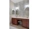 A primary bathroom features a double sink vanity with a seating area, granite counters, and modern wallpaper at 6303 Gentle Ben Cir, Wesley Chapel, FL 33544