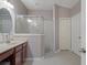 Primary bathroom features a glass enclosed shower and granite topped vanity with wood cabinets at 6303 Gentle Ben Cir, Wesley Chapel, FL 33544