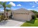A charming single-story home with a two-car garage, featuring lush landscaping and a well-maintained lawn at 6303 Gentle Ben Cir, Wesley Chapel, FL 33544