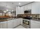 Kitchen with granite counters, stainless steel appliances, and white cabinets at 6303 Gentle Ben Cir, Wesley Chapel, FL 33544