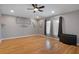 The spacious living room is bright and has wood floors and large windows with neutral-toned curtains at 6303 Gentle Ben Cir, Wesley Chapel, FL 33544