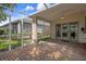 Covered brick patio with screen enclosure and ceiling fan provides comfortable outdoor living space at 6303 Gentle Ben Cir, Wesley Chapel, FL 33544