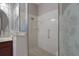 A glass enclosed shower in the primary bathroom has white tiled walls and a decorative tile floor at 6303 Gentle Ben Cir, Wesley Chapel, FL 33544