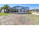 Backyard view showcasing the screened lanai, palm trees, and dolphin accents at 6322 Cocoa Ln, Apollo Beach, FL 33572