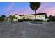 Home exterior with a palm tree, lush landscaping and curb appeal at twilight at 6322 Cocoa Ln, Apollo Beach, FL 33572