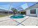 Backyard view showcasing the pool area, screened enclosure, stone tiling, and lush landscaping offering a relaxing outdoor space at 6322 Cocoa Ln, Apollo Beach, FL 33572