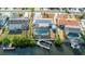 Charming aerial view of a waterfront home with a screened pool, and boat lift, surrounded by tropical foliage at 6508 Senegal Palm Way, Apollo Beach, FL 33572