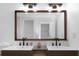 Modern bathroom vanity with dual sinks, wood cabinets, black faucets, and stylish lighting at 6508 Senegal Palm Way, Apollo Beach, FL 33572