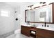 Modern bathroom showcasing marble-look shower, and wood vanity with dual sinks at 6508 Senegal Palm Way, Apollo Beach, FL 33572