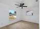 A well-lit bedroom with modern flooring, white walls, and a neighborhood view from the window at 6508 Senegal Palm Way, Apollo Beach, FL 33572
