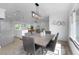 Open concept dining room with modern light fixture, hardwood floors, and stainless steel appliances at 6508 Senegal Palm Way, Apollo Beach, FL 33572