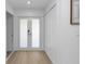 Bright entryway with wood flooring, closet space, and modern double glass doors at 6508 Senegal Palm Way, Apollo Beach, FL 33572