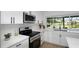 This kitchen boasts stainless steel appliances, modern white cabinetry, and great views of the water at 6508 Senegal Palm Way, Apollo Beach, FL 33572