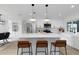 Bright kitchen features stainless appliances, white cabinets, pendant lighting, and a large island with bar seating at 6508 Senegal Palm Way, Apollo Beach, FL 33572