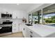 Bright kitchen with stainless steel appliances, modern white cabinetry, and view of the screened pool at 6508 Senegal Palm Way, Apollo Beach, FL 33572