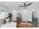 Well-lit living room with a ceiling fan, cozy seating, and views to the outdoors at 6508 Senegal Palm Way, Apollo Beach, FL 33572