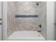Bathroom shower with sleek gray subway tile, glass doors, and modern fixtures at 6508 Senegal Palm Way, Apollo Beach, FL 33572
