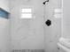 Beautiful bathroom shower with marble-look tiles, a rain shower head, and river rock floor at 6508 Senegal Palm Way, Apollo Beach, FL 33572