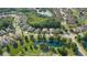 A lovely aerial view shows many homes surrounding by ponds, mature trees, and manicured lawns at 6555 Sparkling Way, Wesley Chapel, FL 33545