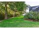 Well-manicured lawn and lush landscaping with mature trees in a private backyard setting at 6555 Sparkling Way, Wesley Chapel, FL 33545